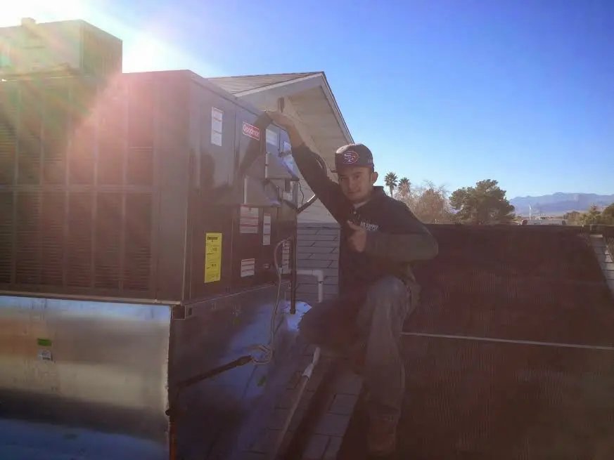 HVAC technician performing Air Duct Cleaning on a rooftop unit in Cedar Rapids